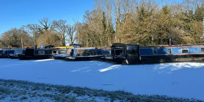 Frozen canal with narrowboats in England