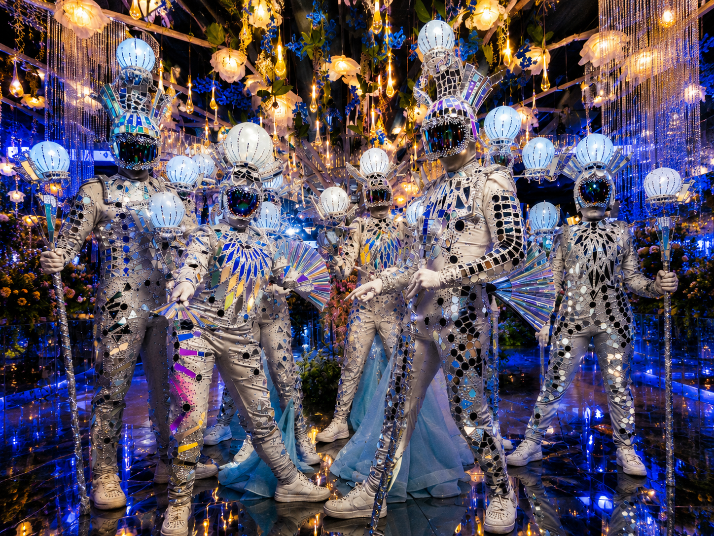 Mirror-costumed performers at an illuminated event