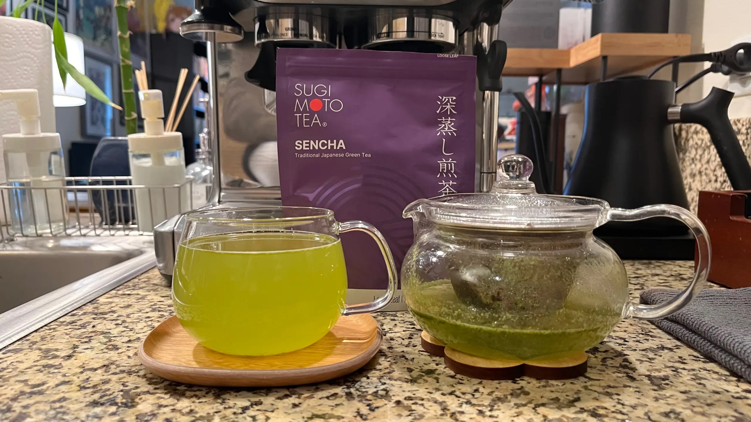 Photo of a cup and pot of Sugimoto Tea's Sencha with the package behind.