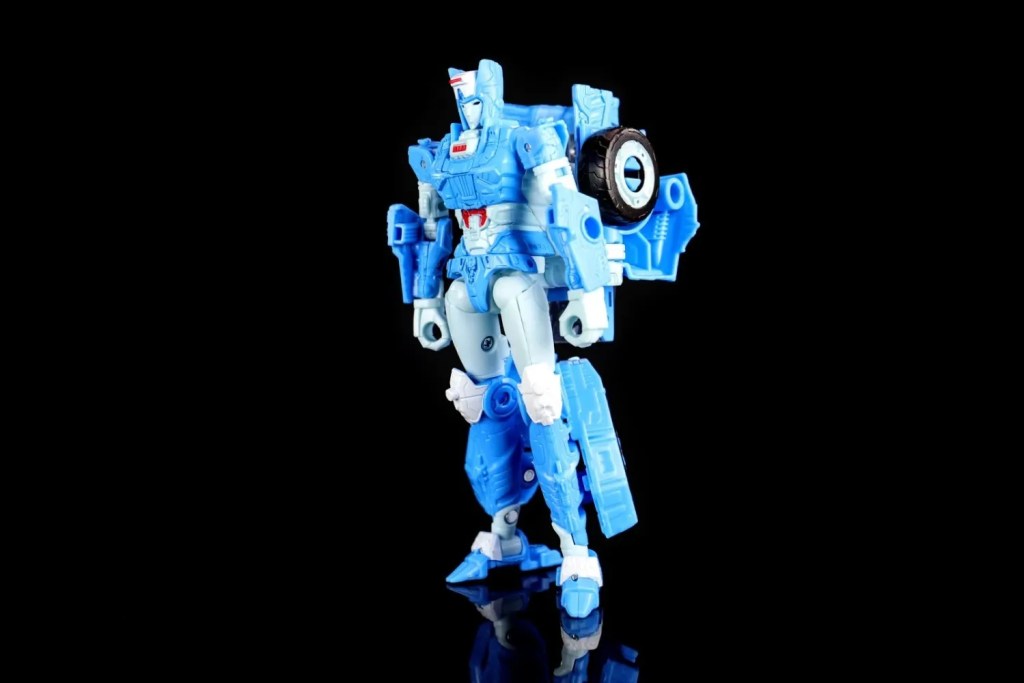 A blue robot figure in a dynamic pose, showcasing fine details like red and white accents and visible battle damage. The figure has a futuristic helmet and armor, and features a modular design with interchangeable parts.
