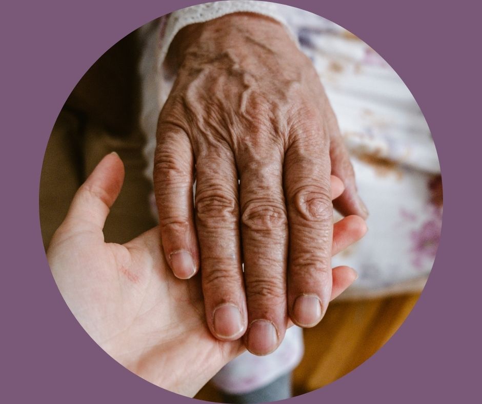 younger person's hand holding older person's hand