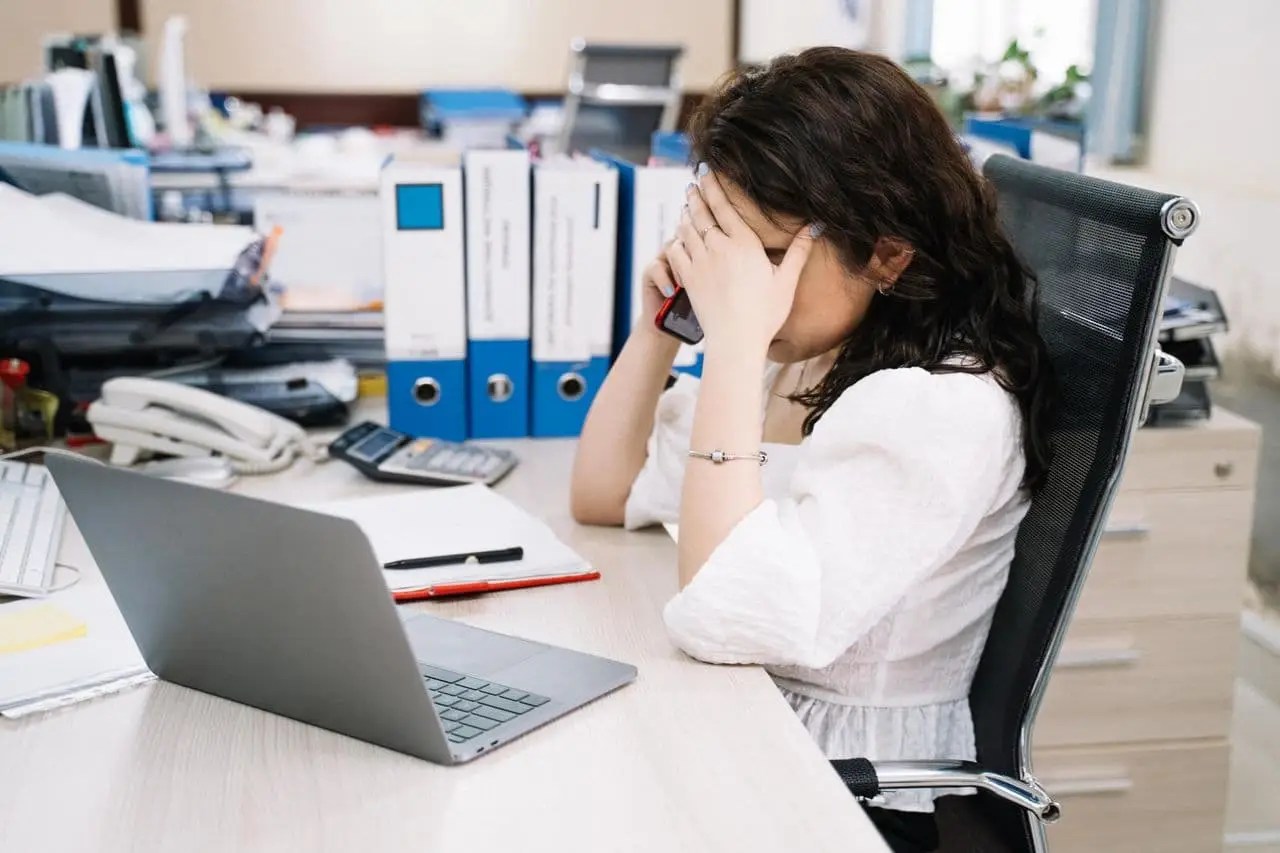 woman-sitting-behind-her-desk-having-a-telephone-call
