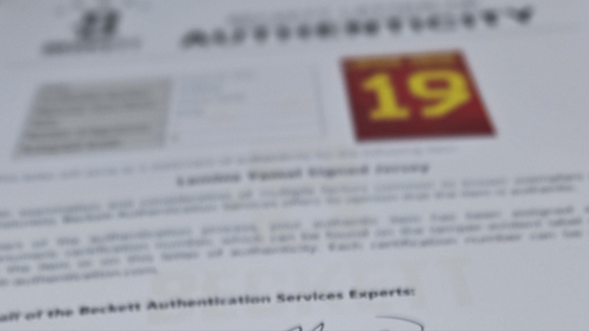Blurry document page with a red badge showing the number 19 in yellow text on the right side.