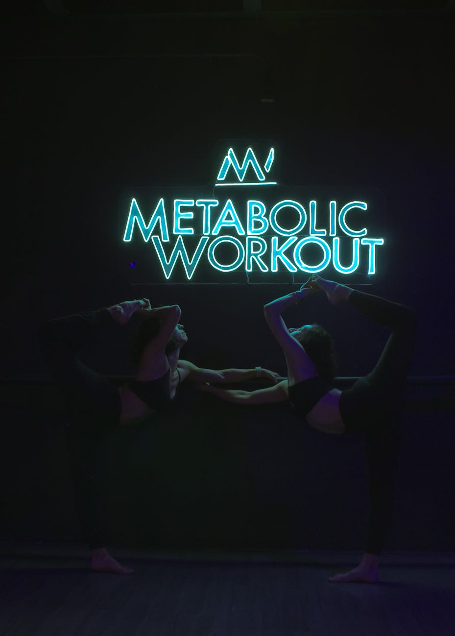 two women stretching under illuminated neon