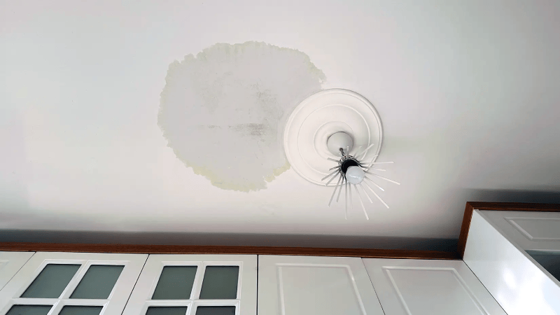 Bucket catching a drip from a leaking ceiling