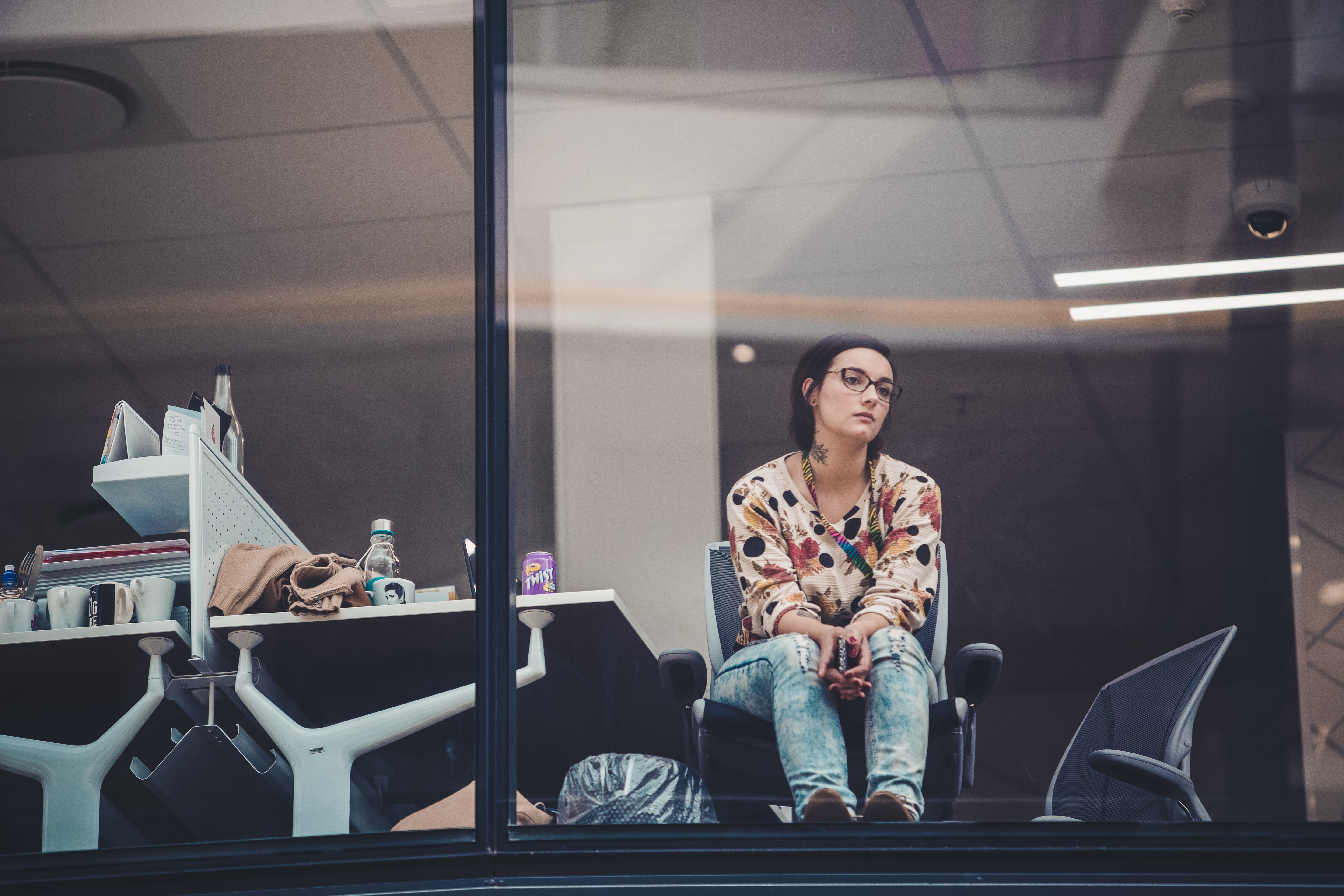 Woman sitting at a desk with a blank stare out the window in a state of dissociation
