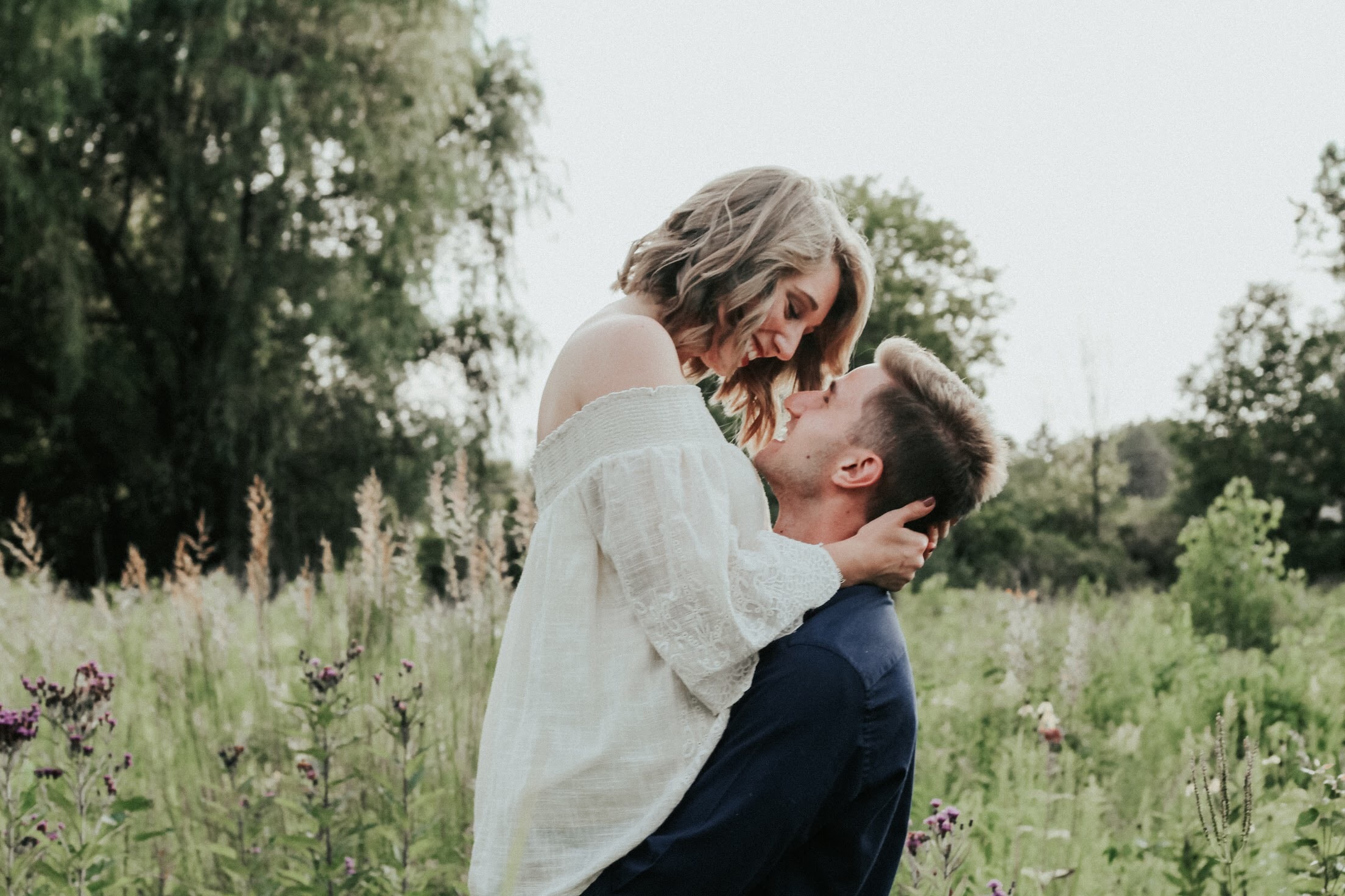 Man lifting woman in the air as they embrace – Dating Up