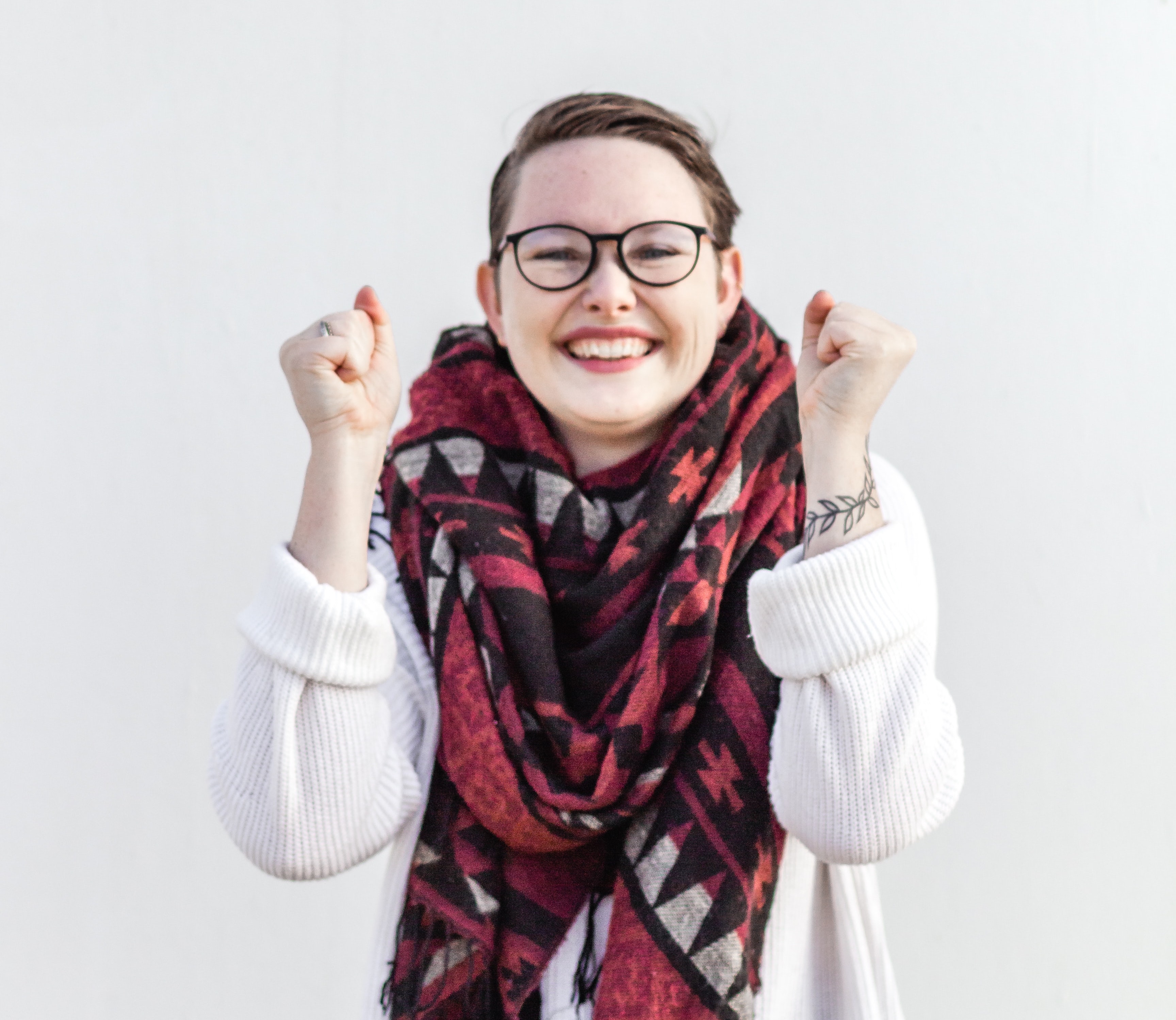 Jubilant woman, smiling and holding her arms up in a winning gesture.