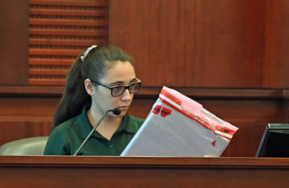 Flagler Sheriff's Crime Scene Investigator Gabriella Massa with one of the two laptops where Durso stored the image in question. (© FlaglerLive)