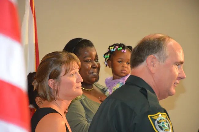 Saviors and survivors: Undersheriff Rick Staly presented Lifesaver Awards to 911 operator Genice Caccavale, in the foreground, and Alicia Fennell, who held her grandchild, Kelisa, to whom she administered CPR as she heard instructions from Caccavale over the phone Saturday, averting a drowning. Leon’ntashia Leggette, 8, who brought Kelisa out of the water, was behind Caccavale. (© FlaglerLive)