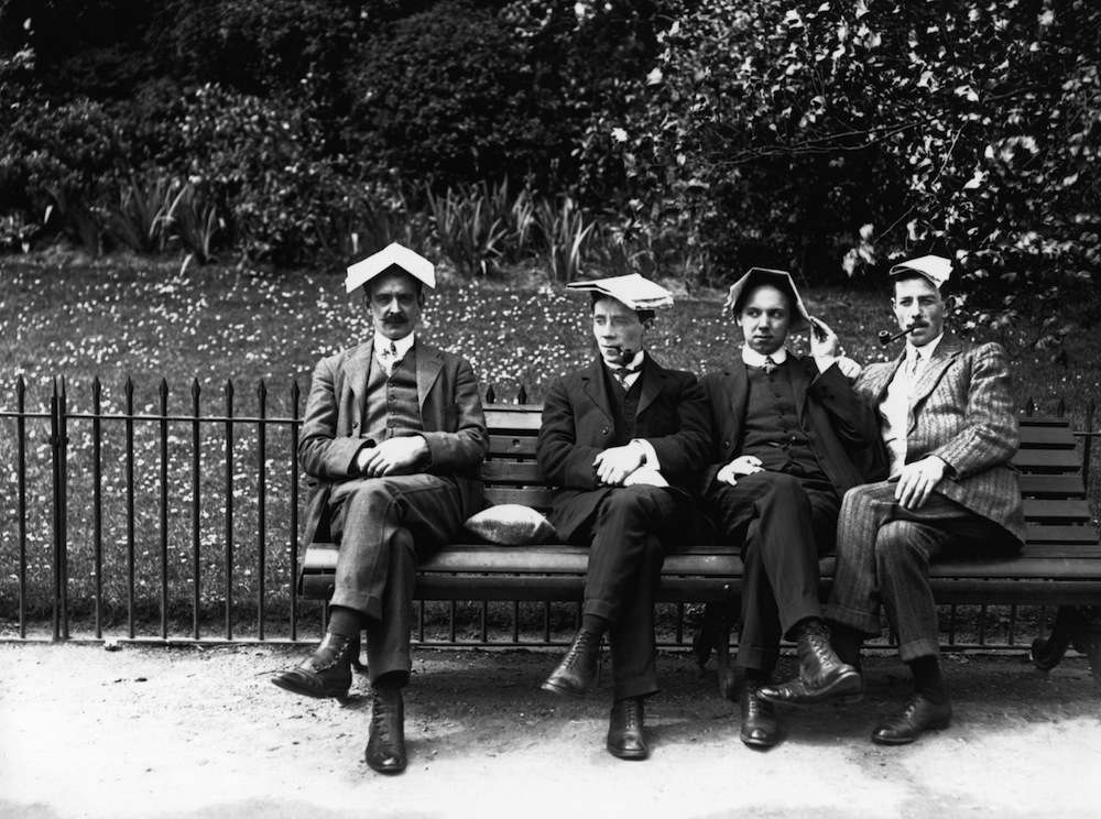 1st July 1913: Men cover their heads with newspapers to protect them from the summer sun. (Photo by Topical Press Agency/Getty Images)
