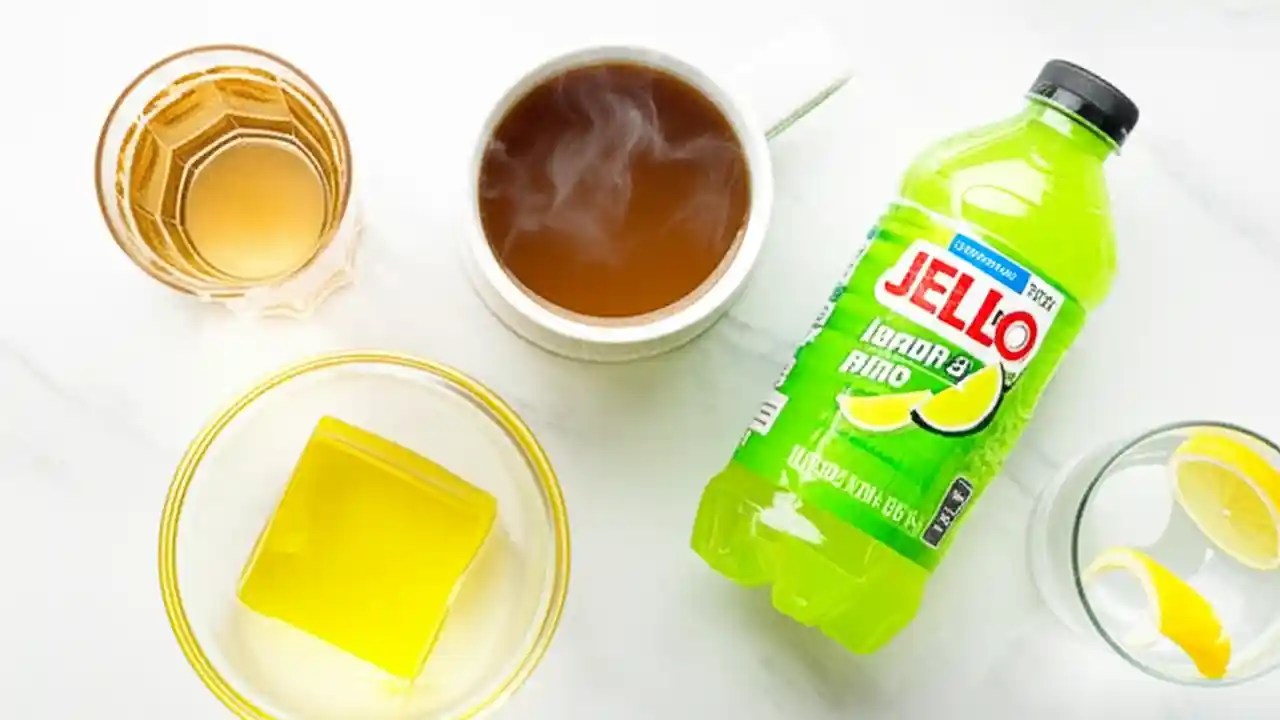 An arrangement of approved clear liquids for colonoscopy prep, including water, black coffee, yellow Jell-O, and light-green sports drink.