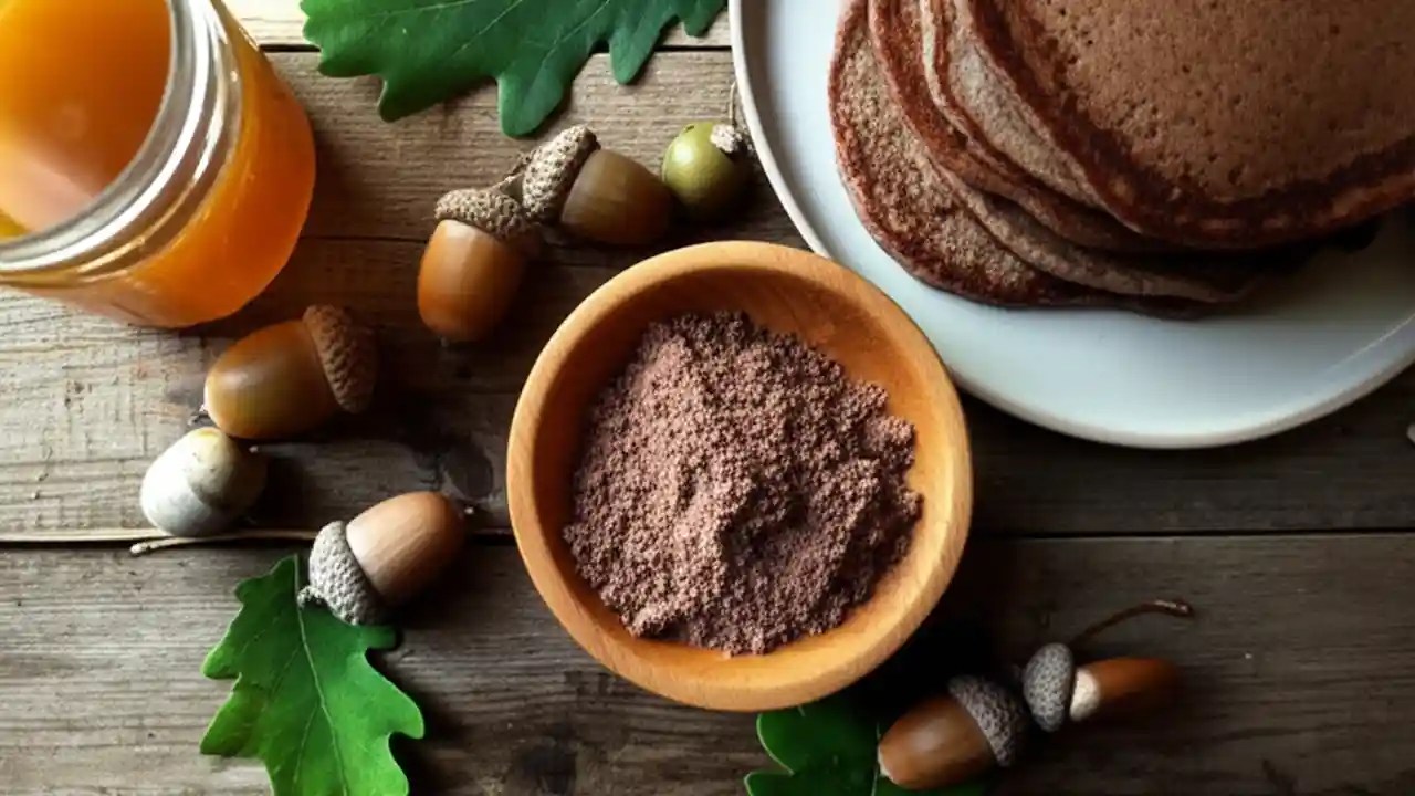 A table displaying the stages of acorn processing: whole acorns, shelled nuts, a jar of leaching acorns, and a pile of finished acorn flour.