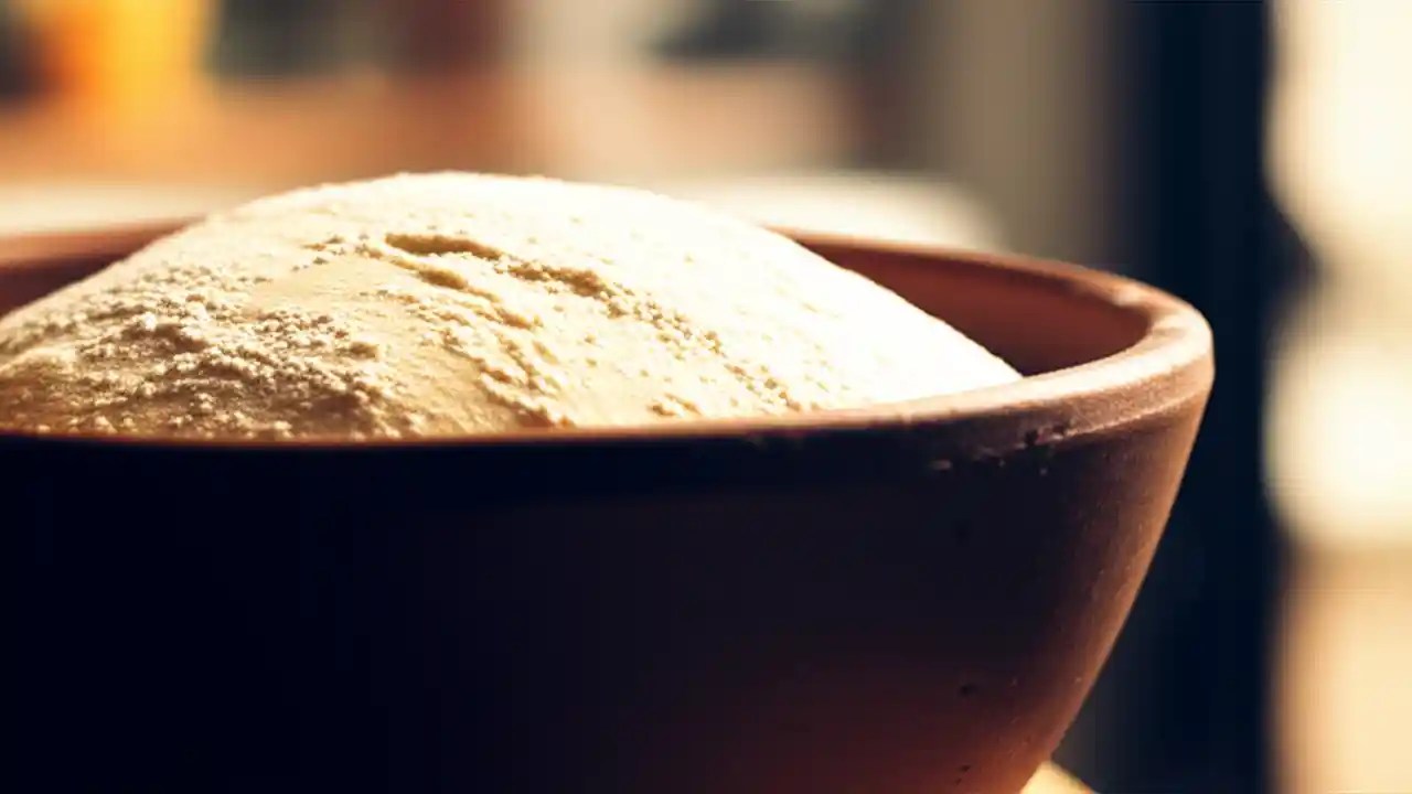 A bowl of perfectly risen bread dough, showcasing the ideal texture and volume achieved at the correct rising temperature.