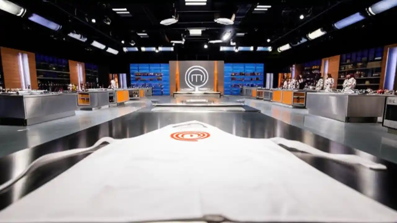 A pristine MasterChef kitchen with a white apron on a steel counter, symbolizing the show's return in 2026.