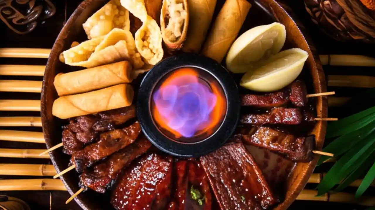 A top-down view of a pupu platter featuring egg rolls, crab rangoon, and spareribs at a tiki restaurant.