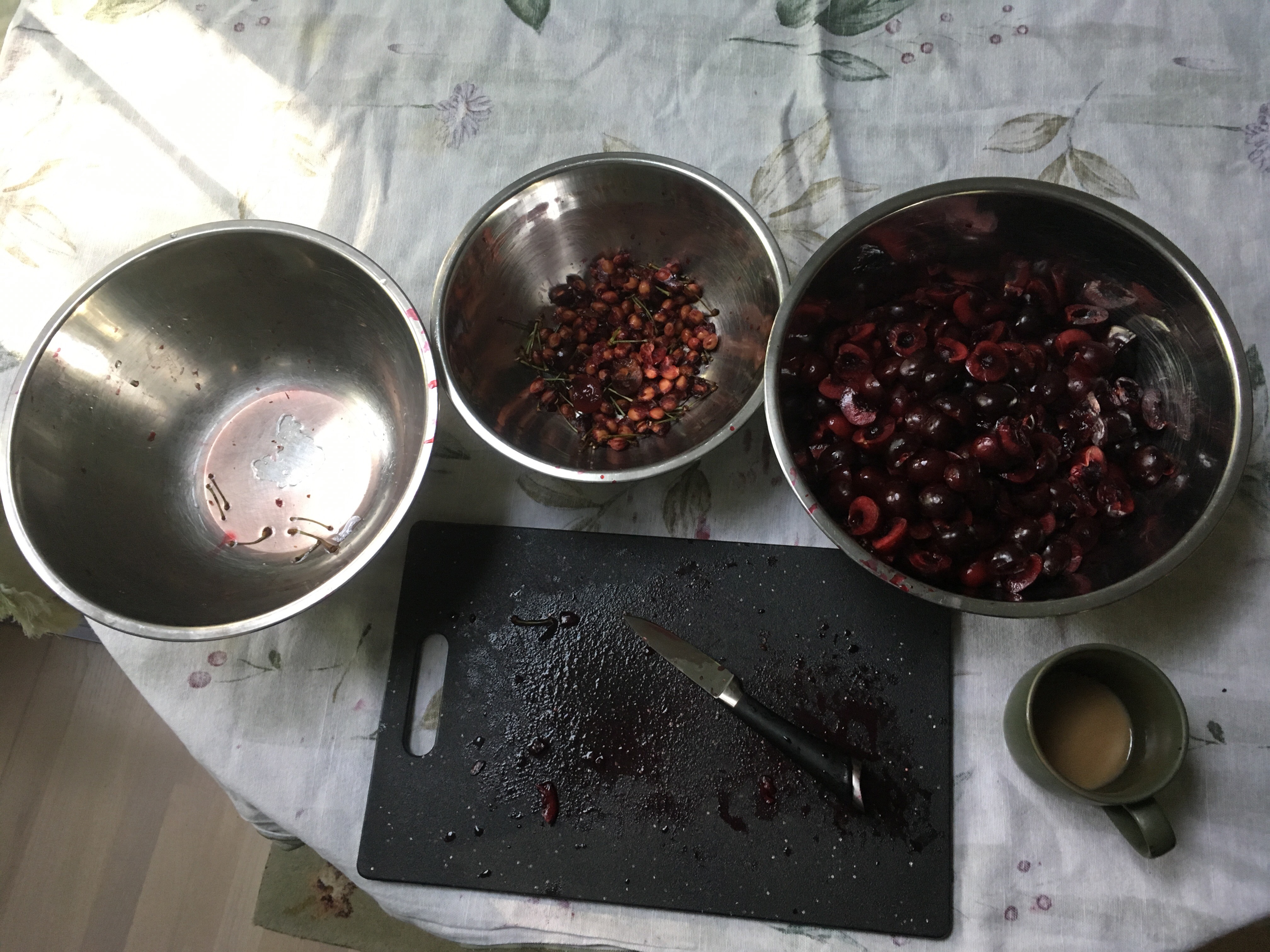 Pitted Cherries in a bowl with a knife and board