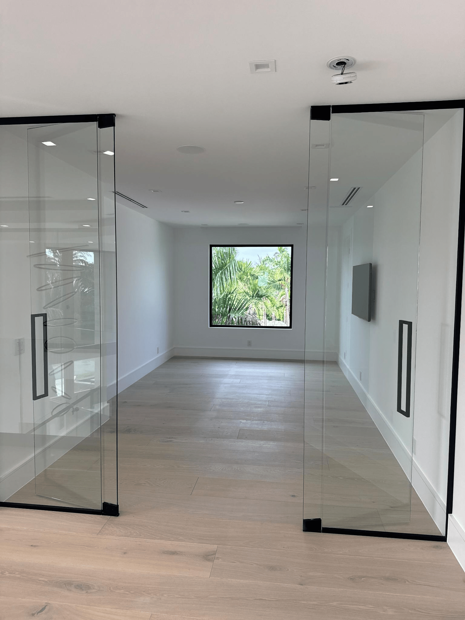 A new office space in a residential home with a modern glass door and wall.