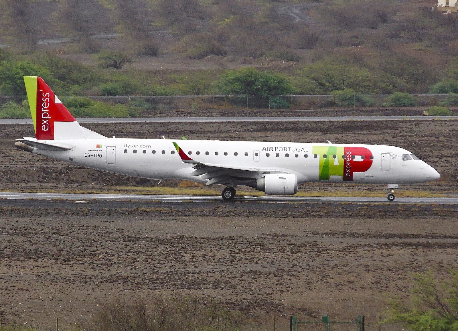 TAP Air Portugal Express Embraer E190 aircraft (registration CS-TPO) taxiing at São Vicente Airport in Madeira, with the airline’s red, green, and white livery clearly visible.