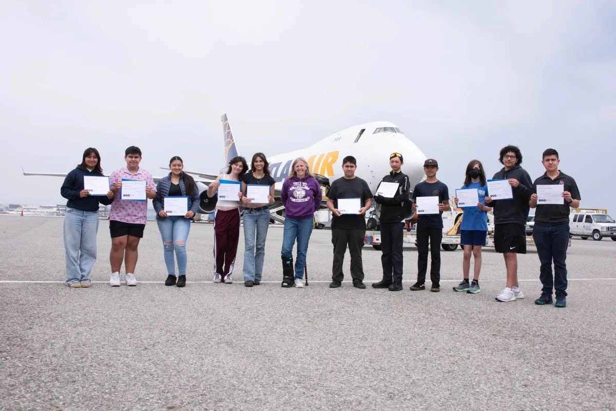 Photo of Flight Path Flyers Class of Spring 2023 on the airfield in front of an Atlas Air 747 after graduation