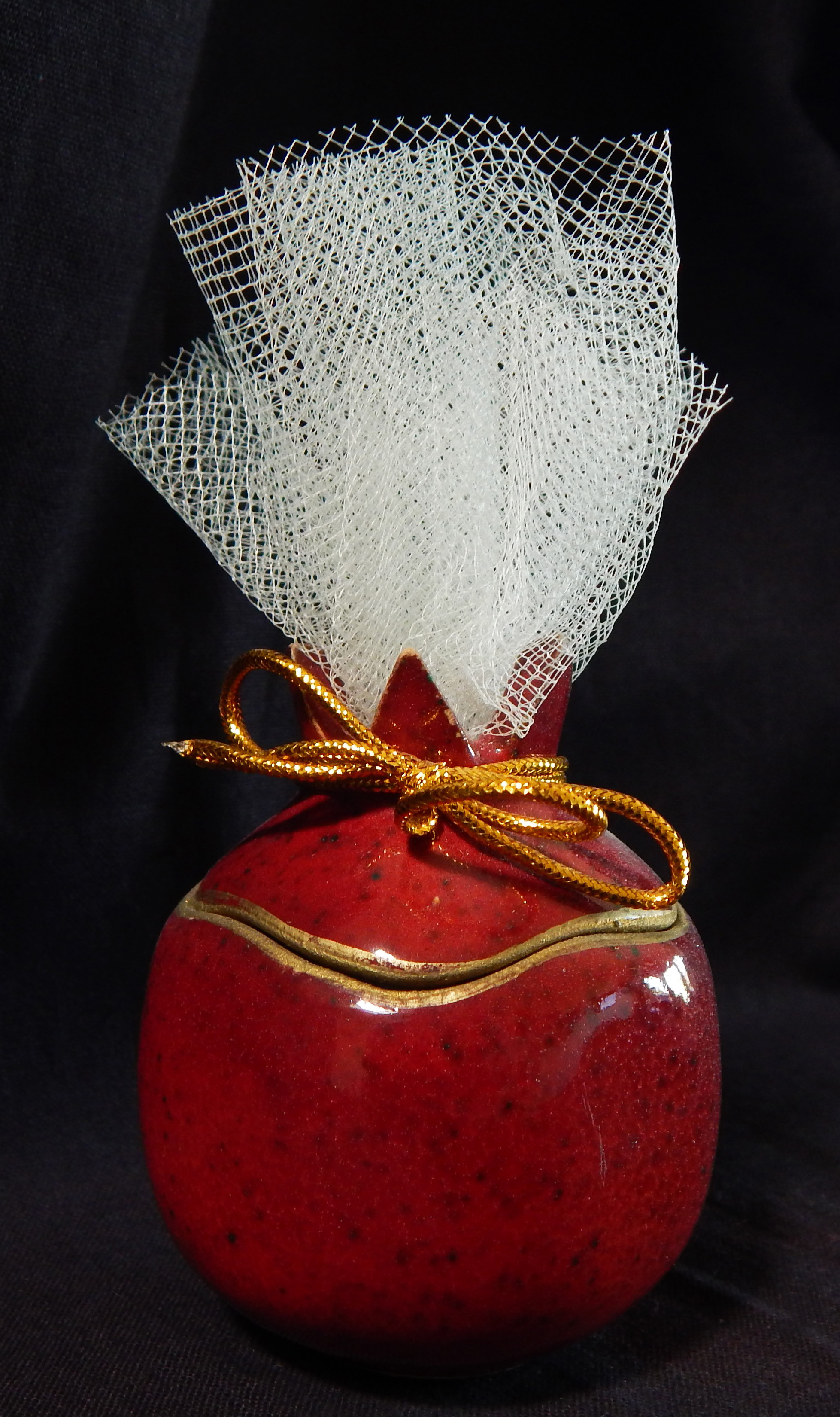 Pomegranate container with Jordan almonds in netting