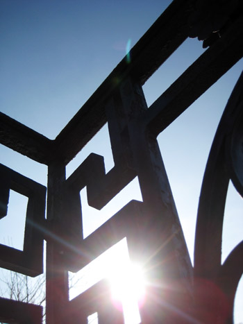 sun shining through a wrought iron gate