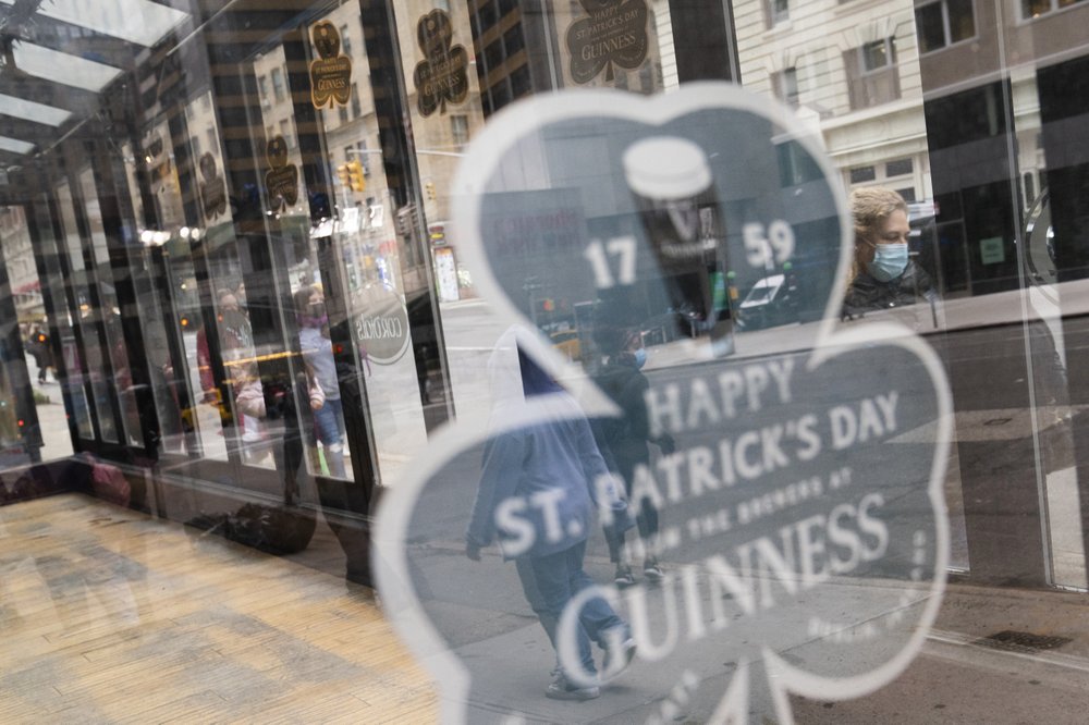 Pedestrians pass a shuttered dining area outside The Stagecoach Tavern on Saint Patrick's Day in midtown Manhattan, Wednesday, March 17, 2021, New York. (AP Photo/John Minchillo)