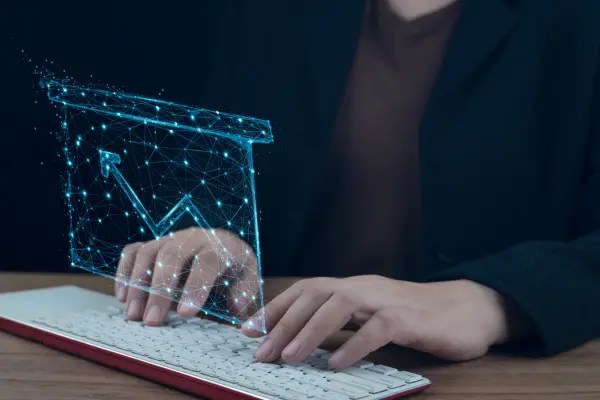 A imagem representa a interseção entre tecnologia e segurança digital. O holograma com um gráfico em ascensão simboliza a importância da análise de dados, proteção contra riscos tecnológicos e a necessidade de estratégias eficazes para evitar ameaças cibernéticas.