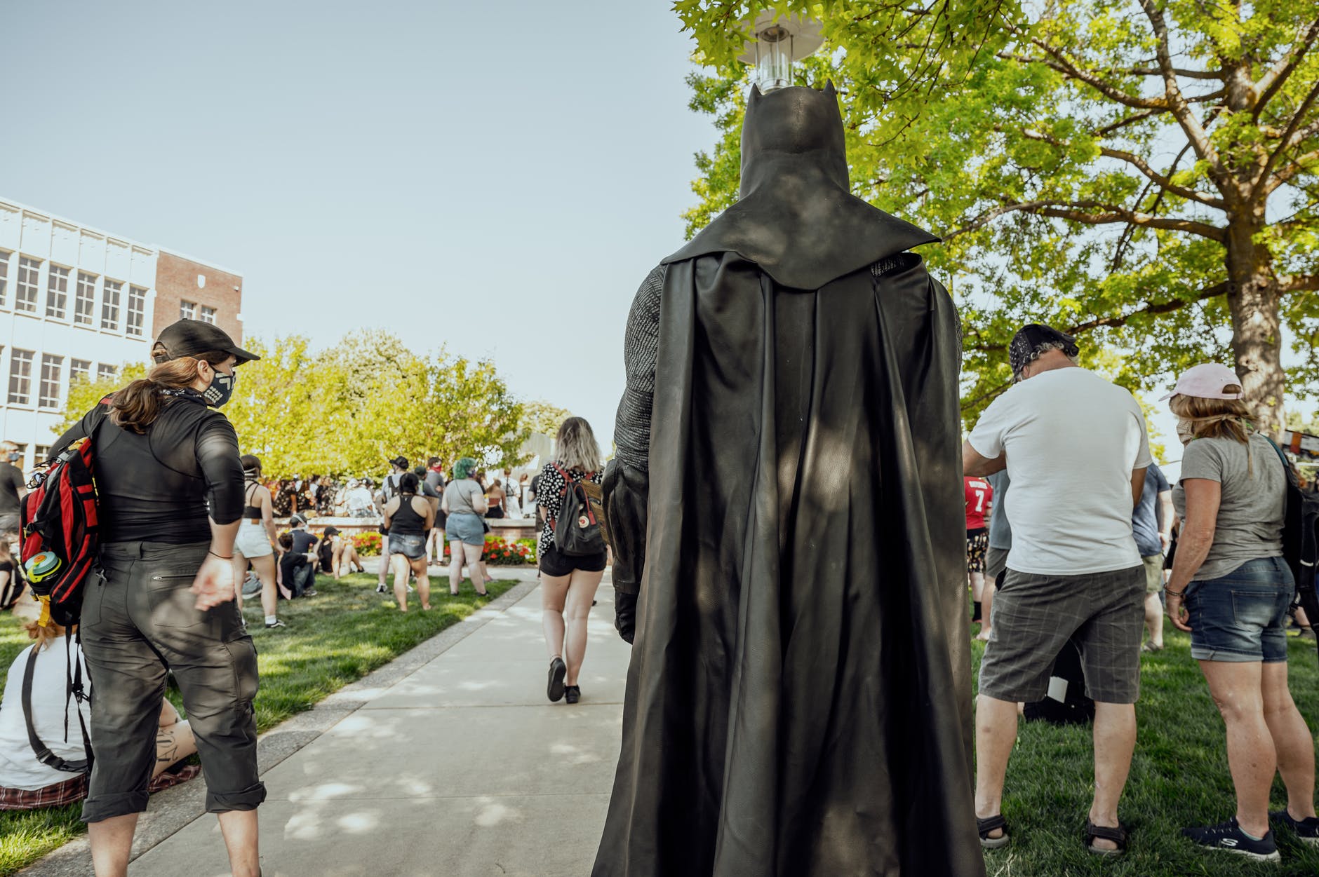 anonymous person in superhero costume walking in park