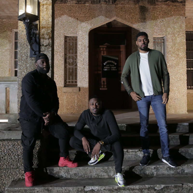 A full body hero shot of the Ghost Brothers Marcus Harvey (left), Dalen Spratt (center), and Juwan Mass in front of the location for the investigation at Gothic Jail in DeRidder, LA as seen on Travel Channel.