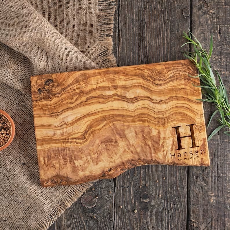 Olive wood cutting board with monogram engraved in the lower right corner.