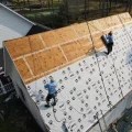 Professional roof installers applying storm-resistant shingles for a Fortified Roof.