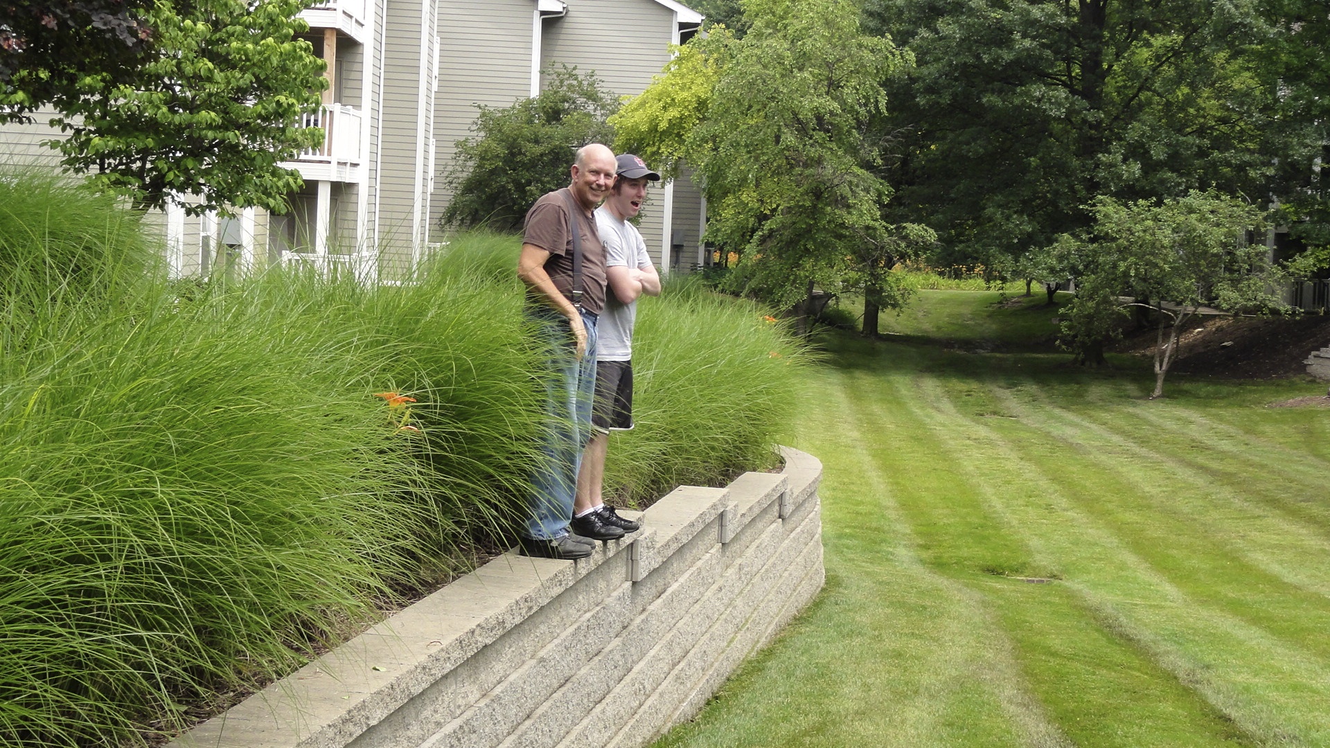 Dad says Matt used to play "soccer ball" in this grassy field behind our building. Matt would wait at the wall and Dad would walk around to lift him down.