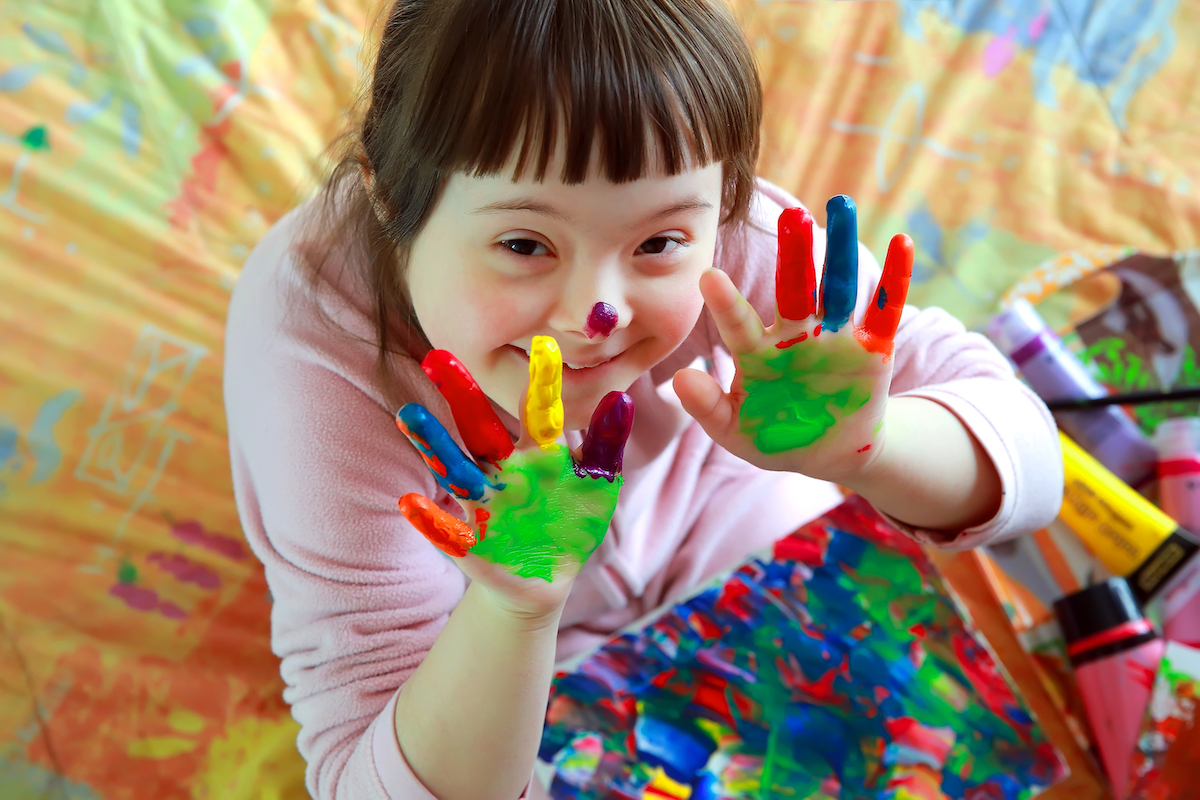 niña con las manos pintadas de distintos colores