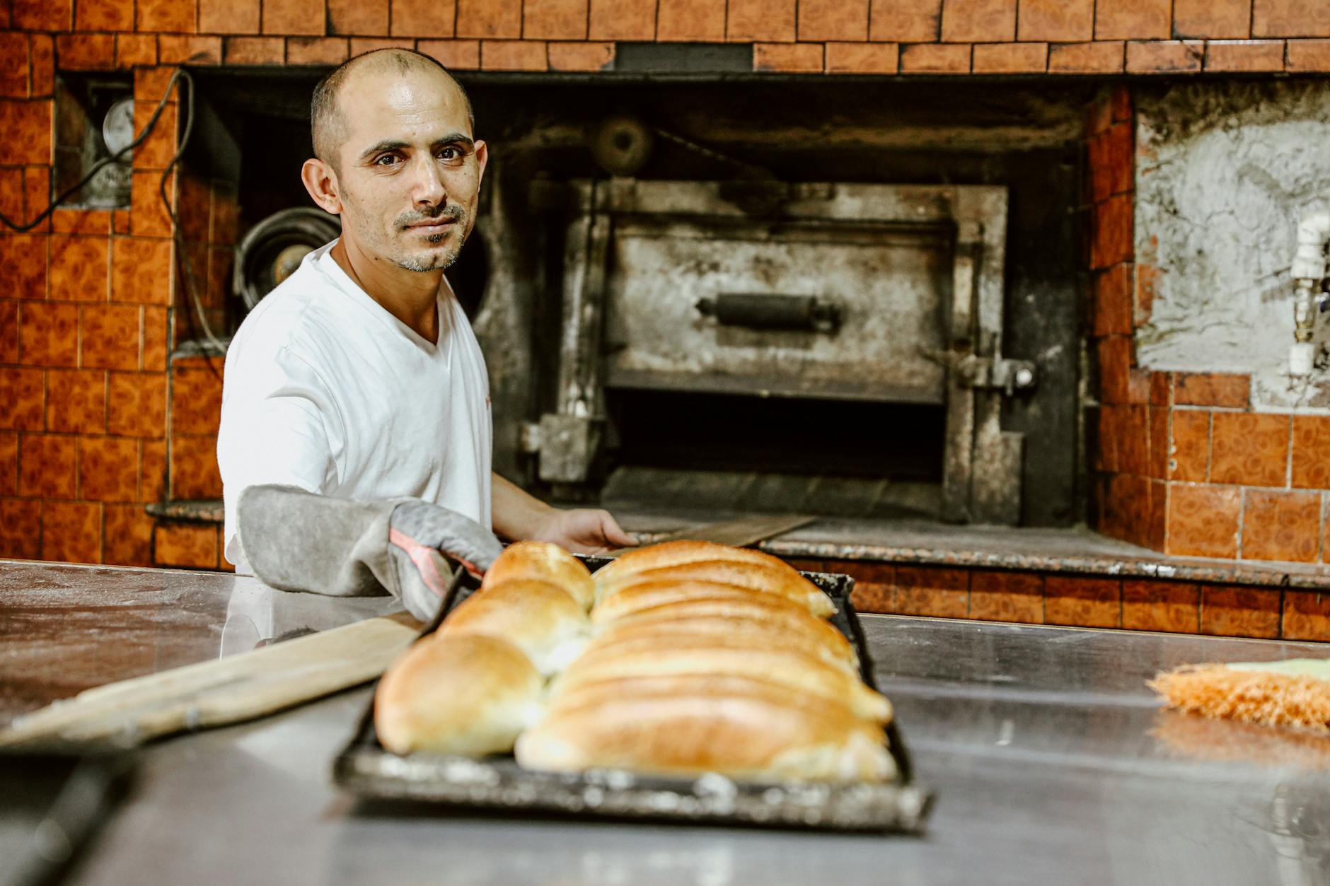 baker presenting freshly baked bread in rustic oven