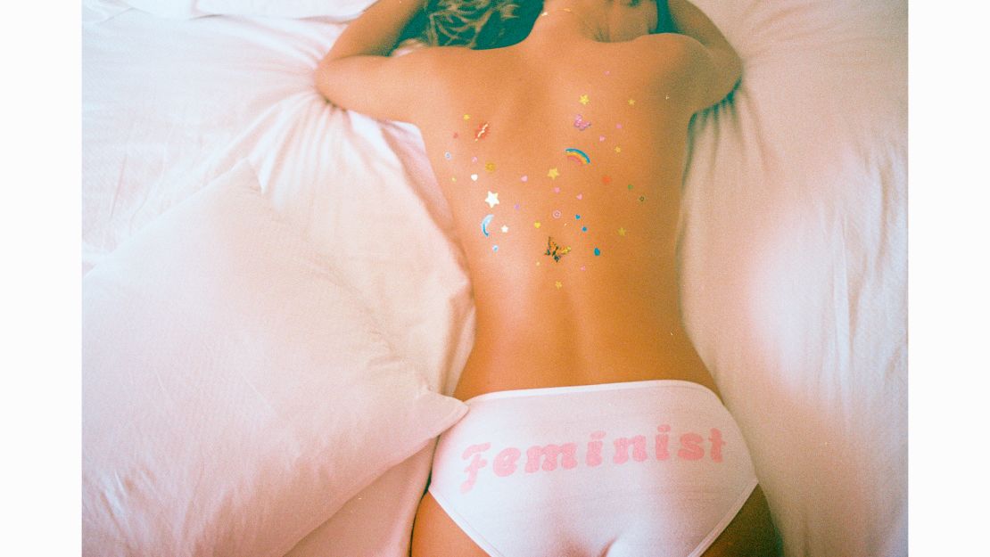 Woman seen from behind with underwear that says 'feminist' across the bottom.