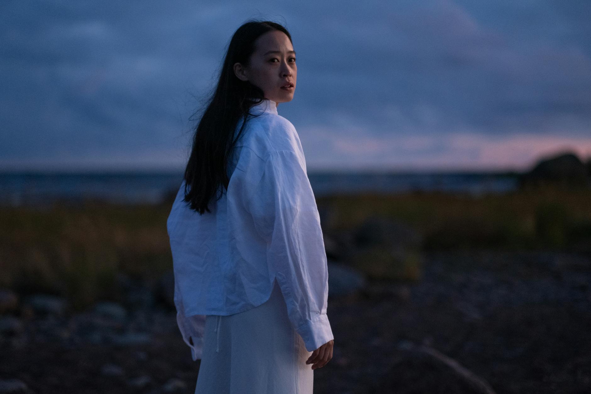 a woman in white long sleeves looking over shoulder