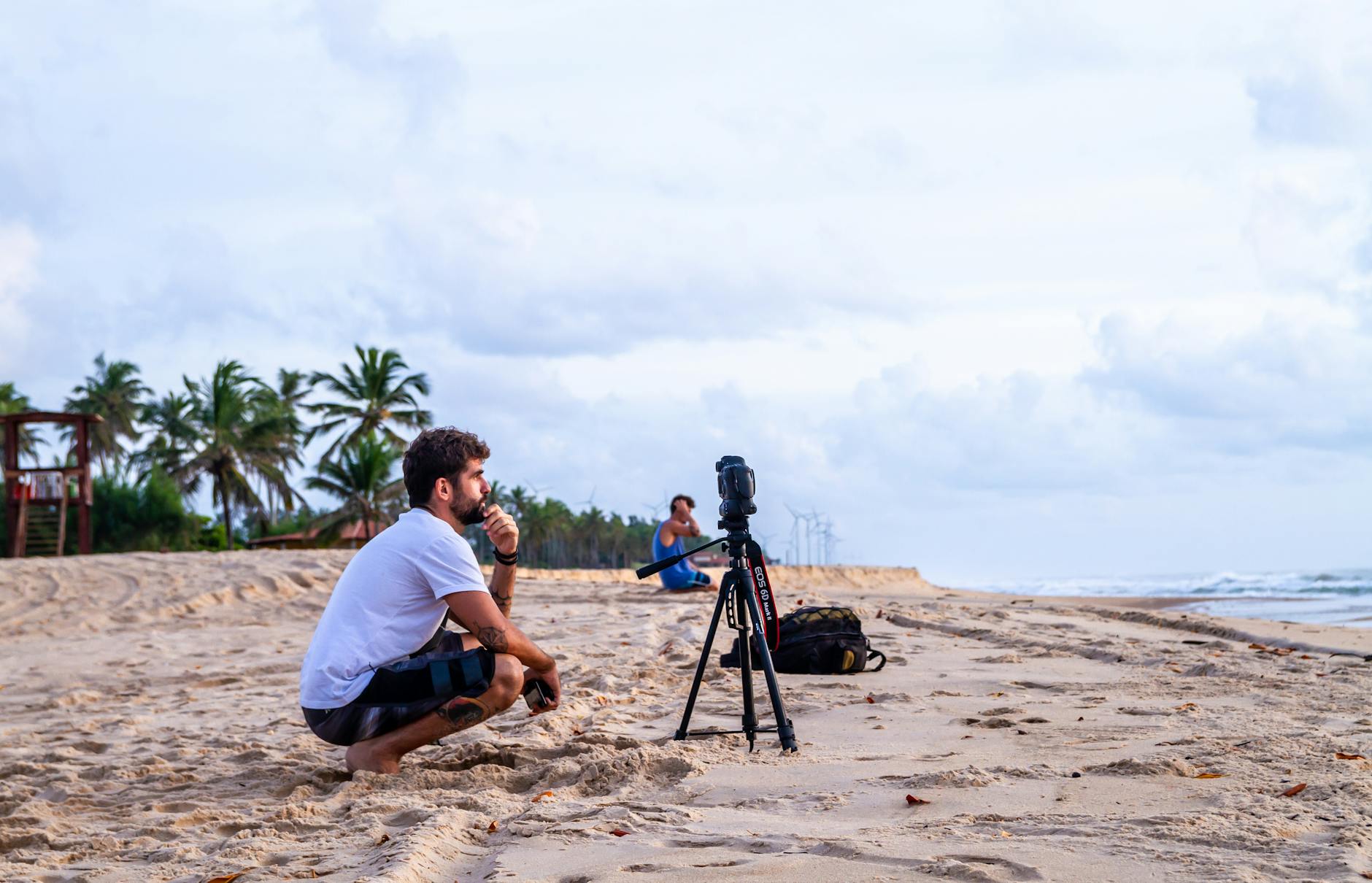 man crouching on shore