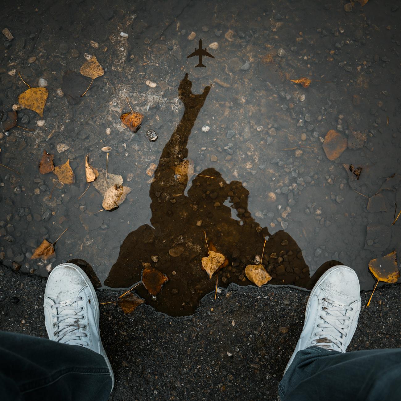 person wearing white low top shoes taking photo of water