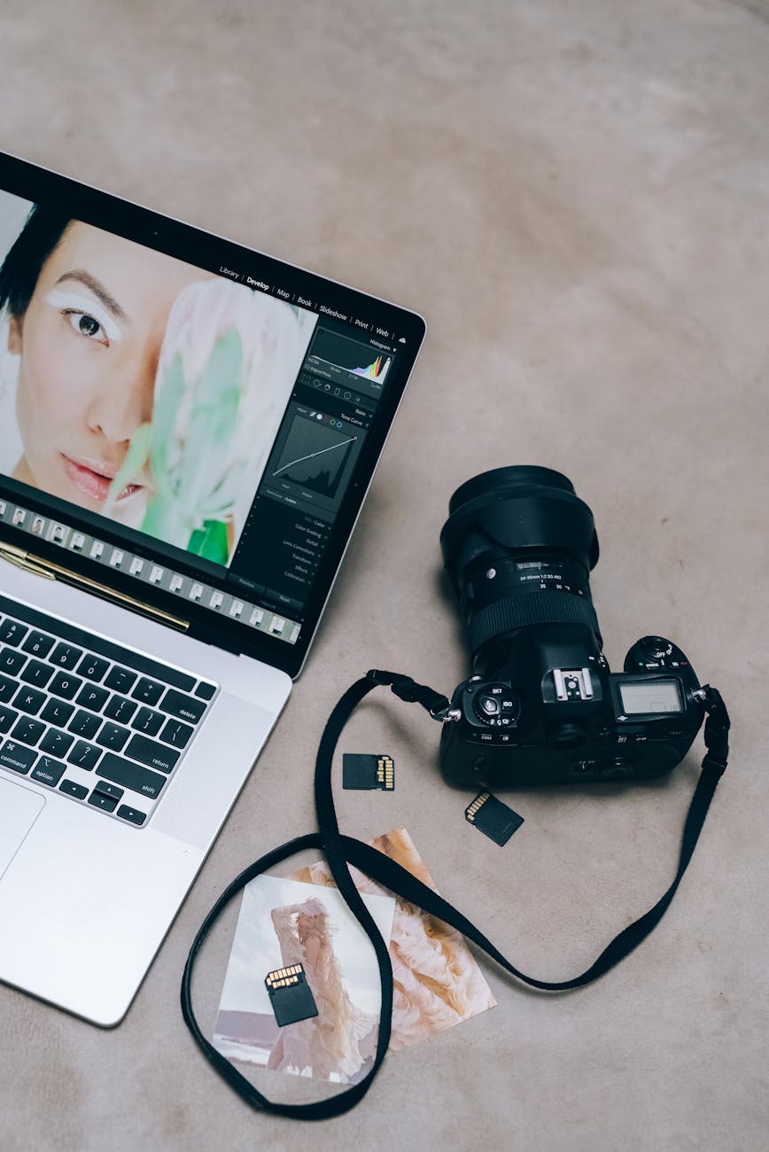 a laptop and a black camera on a concrete surface