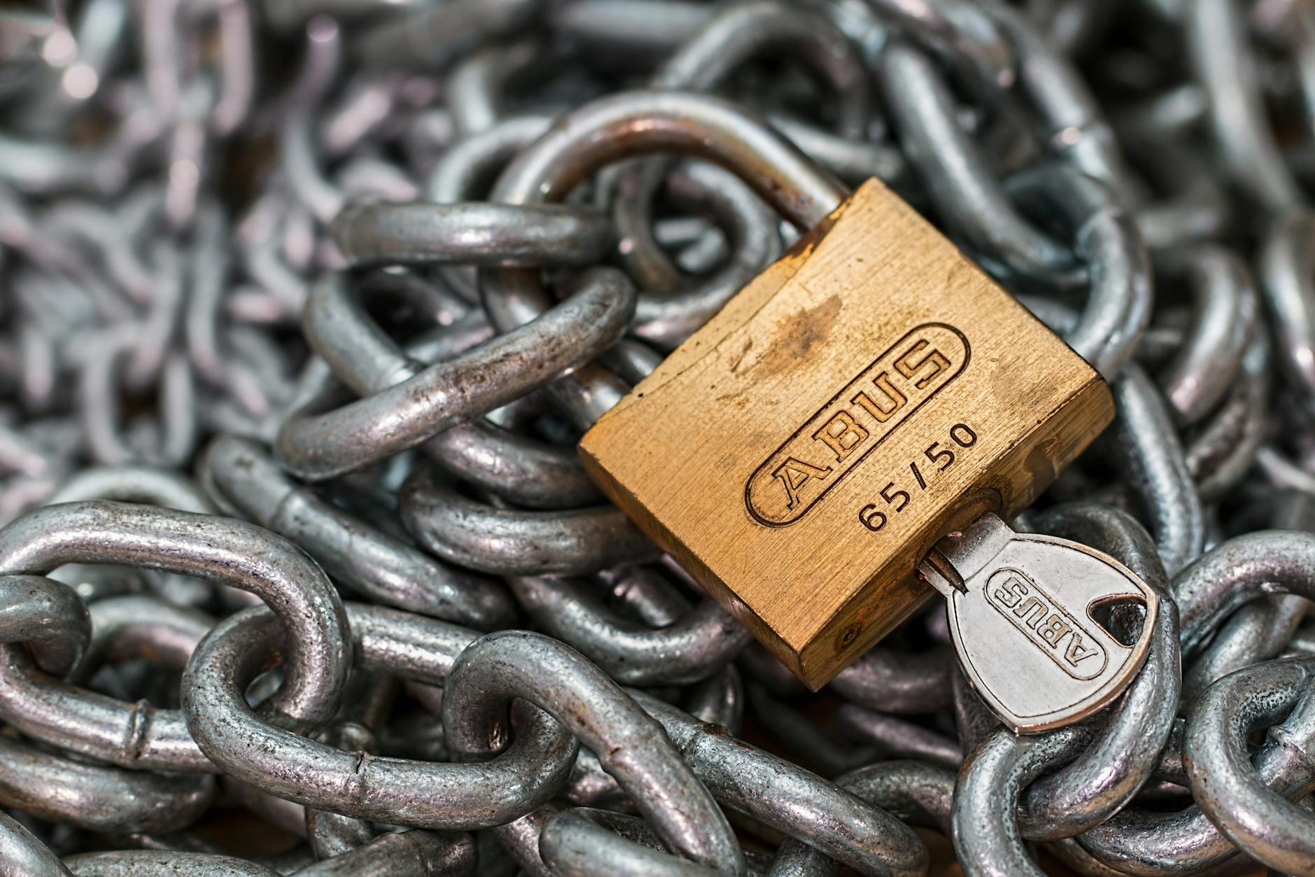 gold colored abus padlock with key