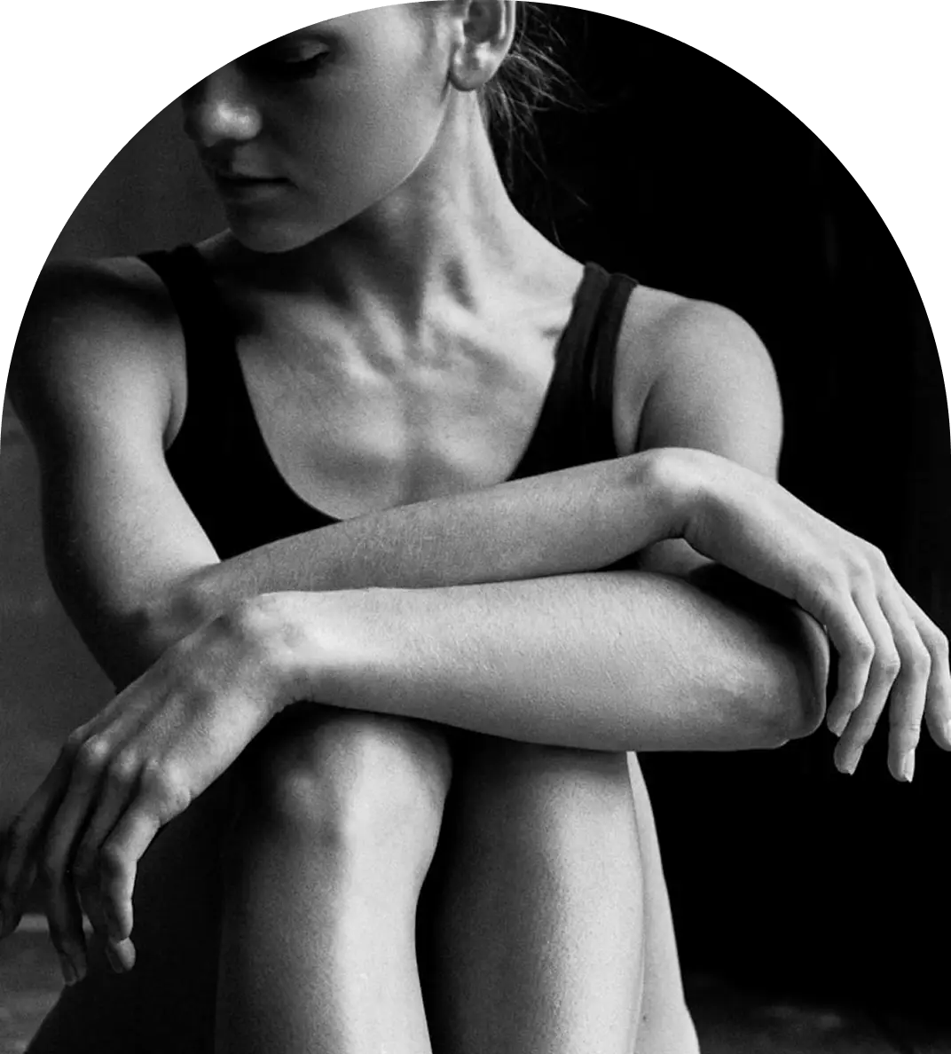 Black and white photo of a woman sitting with crossed arms