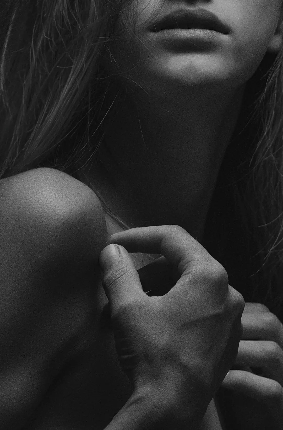 Black and white portrait of a woman's lips and shoulder