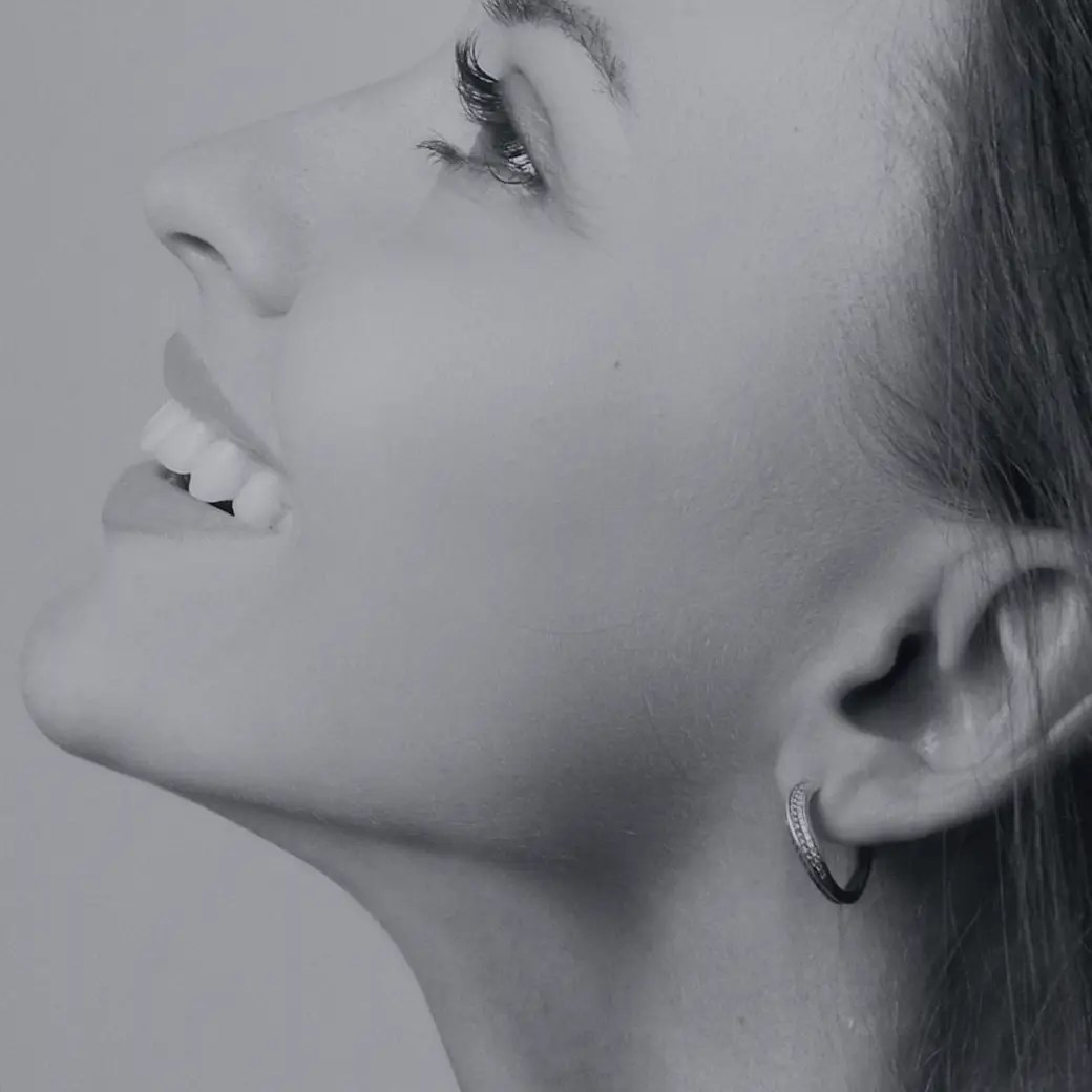 Side profile of a smiling woman showing a defined jawline and neck
