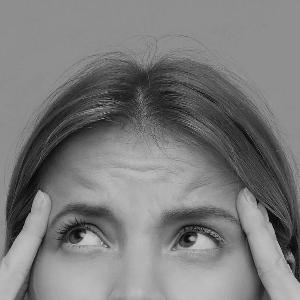 Woman touching her forehead lines