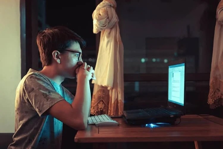 a boy looking intently at a computer screen