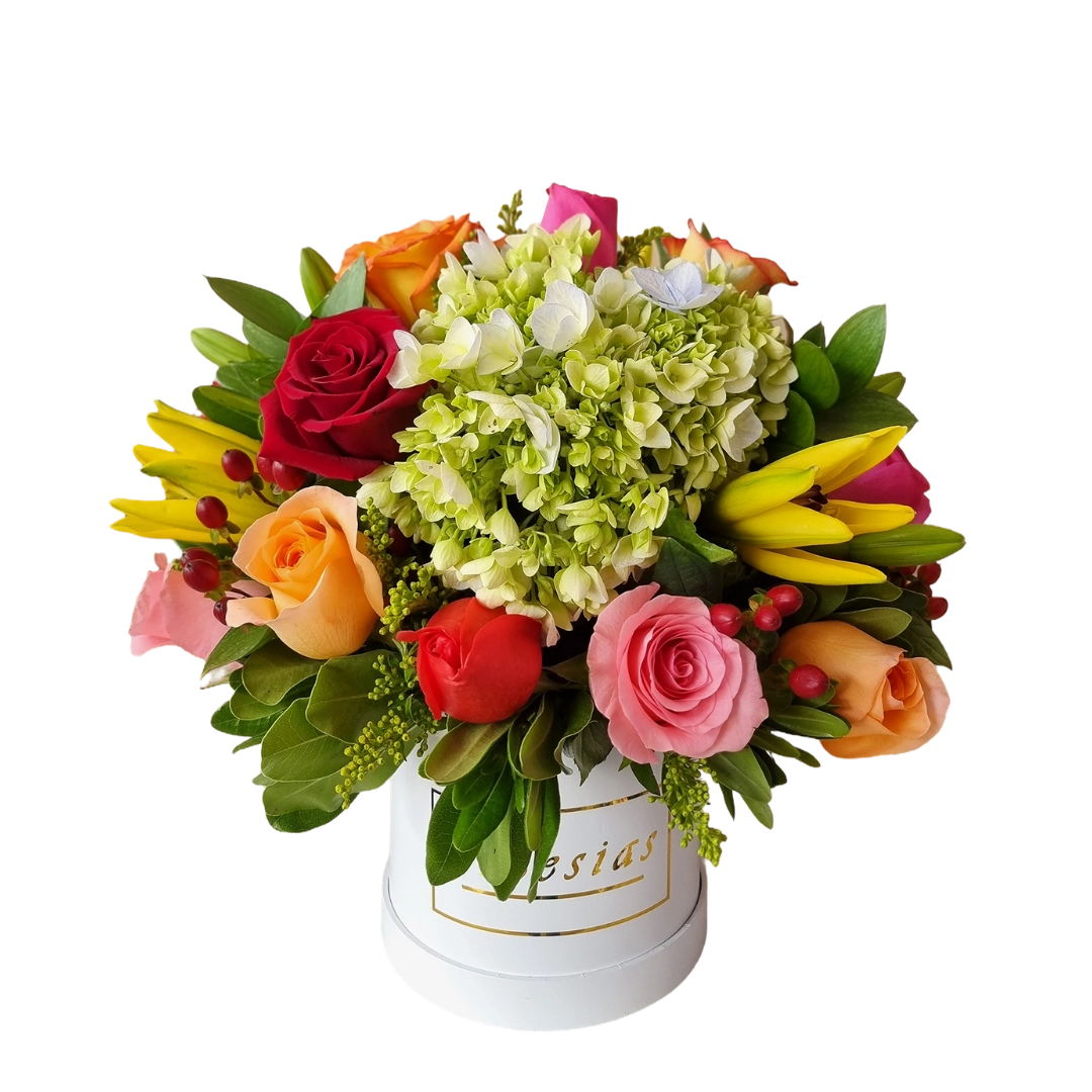 Arreglo floral con rosas, hortensias y flores amarillas en una caja blanca