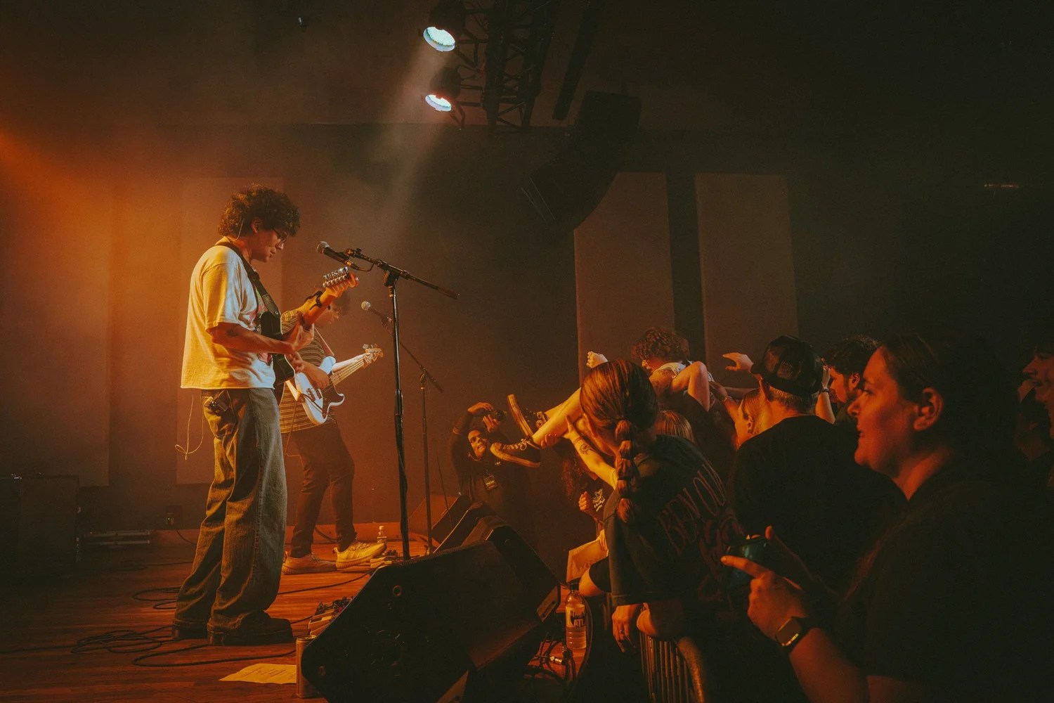 Musicians performing on stage with audience watching at a live concert.