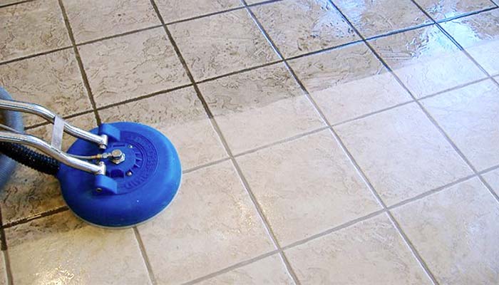 A device cleaning tiles in the middle with half of the side clean while the other half is still dirty.