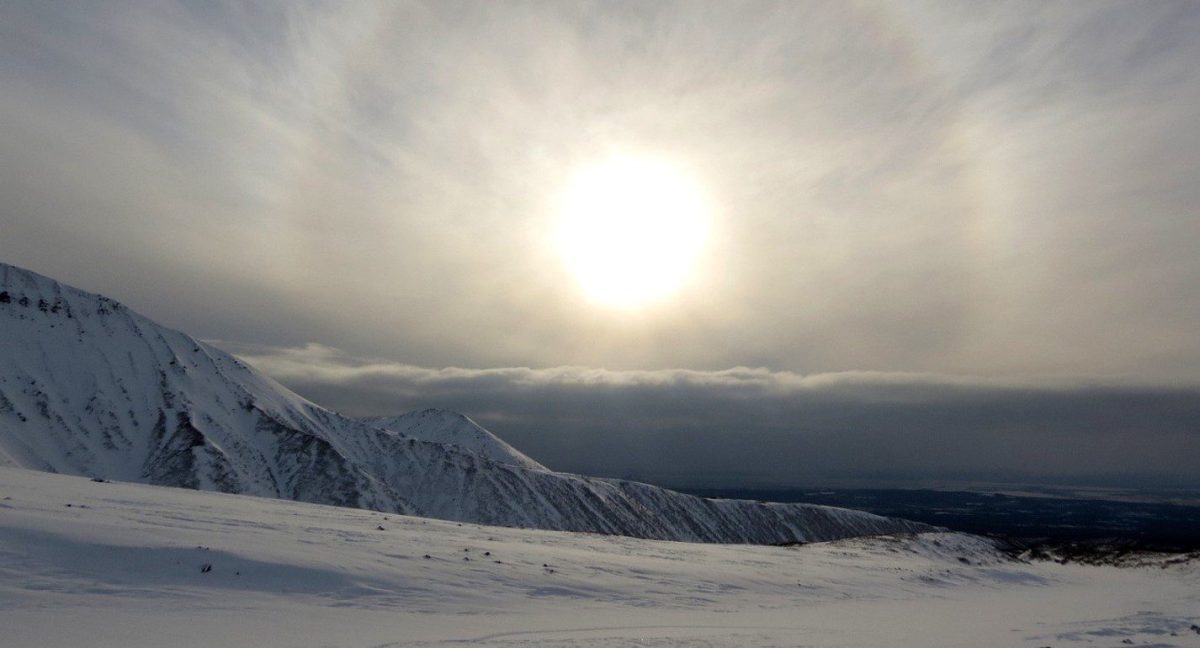 Image of the sun over an icy and snowy field